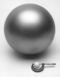 Large aluminum ball shown with golf ball in calipers